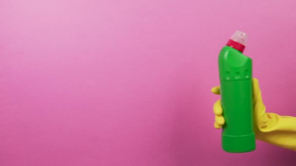 Grüne Flasche mit Haushaltschemikalien und einer Hand in Gummihandschuhen. — Stockvideo