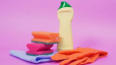 Close-up of home cleaning tools. Plastic bottle of cleanser and latex gloves.