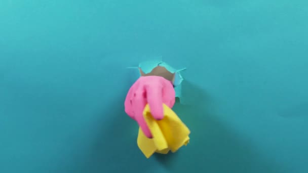 Eine Hand in einem rosa Gummihandschuh hält einen gelben Putzlappen, ein zerlumptes Loch. — Stockvideo