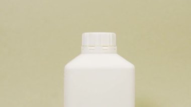 Yuvarlak şapkalı beyaz plastik şişe. Ev kimyasalları..