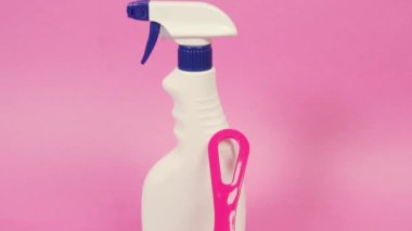 İçinde ev kimyasalları olan plastik bir sprey şişesi ve bir cam temizleyici..