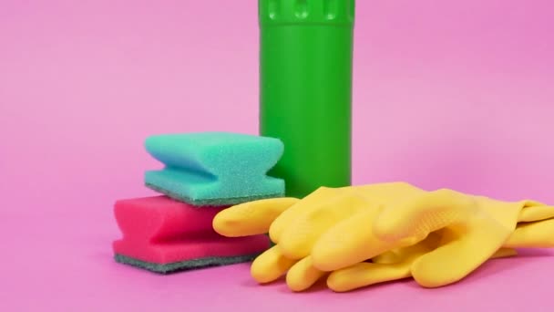 Una bottiglia di plastica verde di prodotti chimici, due spugne e guanti di lattice arancione. — Video Stock