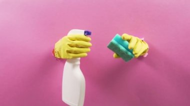 Sünger tutan sarı eldivenli eller ve cam silmek için sprey..