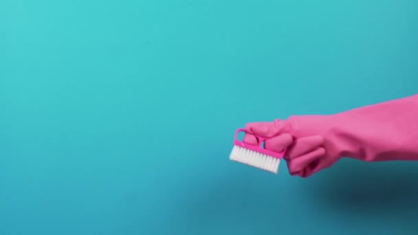 À direita, uma mão de luva rosa com um pincel de limpeza de plástico duro. — Vídeo de Stock
