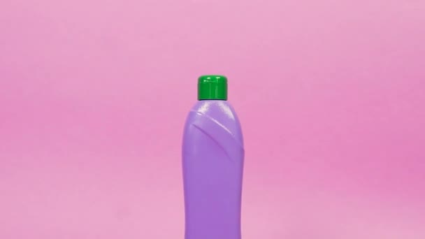Фіолетова пластикова пляшка з зеленою кришкою та побутовими хімікатами . — стокове відео