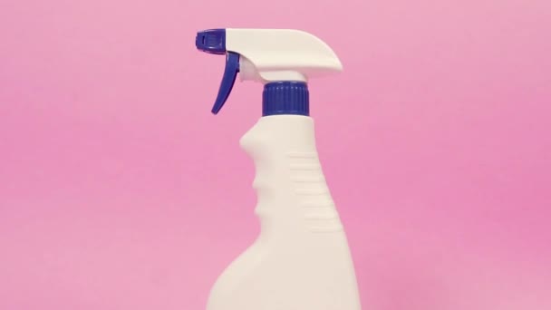 Botella de spray blanco con productos químicos domésticos. Fondo de color sólido rosa brillante. — Vídeos de Stock