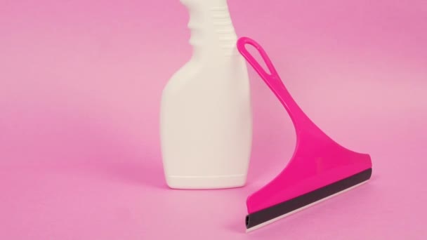 家庭用化学物質と窓掃除機のボトル。明るいピンクの背景. — ストック動画