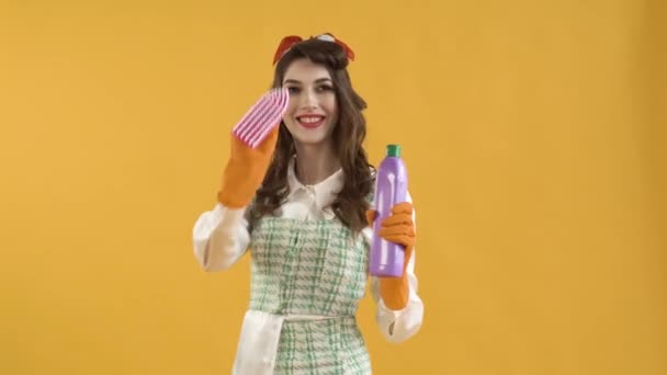 Eine junge Frau bewegt einen Pinsel in der Luft und hält eine Flasche mit Haushaltschemikalien in der Hand — Stockvideo