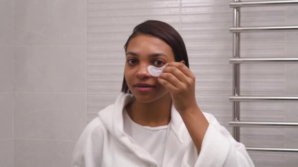 Mujer hermosa joven utiliza parches de ojos blancos, anti-arrugas. Hidratación de la piel. — Vídeo de stock