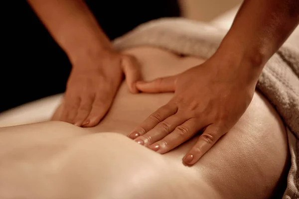 Close-up das mãos massagistas nas costas de uma jovem mulher. Massagem de bem-estar. — Fotografia de Stock
