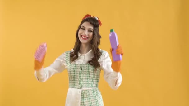 A young woman dances with a brush and household chemicals in her hands. — Stock Video