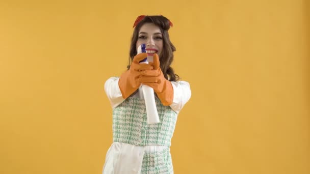Una mujer joven presiona un botón en un spray limpiador de ventanas. Estilo pin-up. — Vídeos de Stock