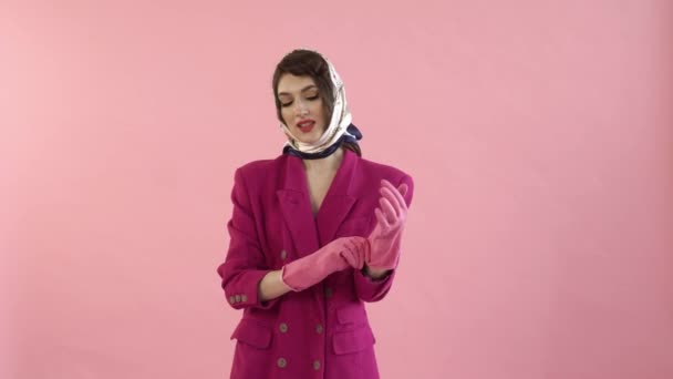 Eine stylische Pin-up-Frau mit hellem Make-up und Gummihandschuhen beginnt zu putzen. — Stockvideo