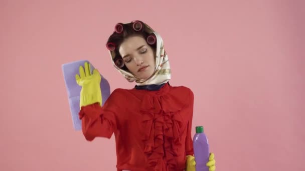 Een vrouw in een rode blouse en haar krulspelden is moe van het schoonmaken van het huis. — Stockvideo