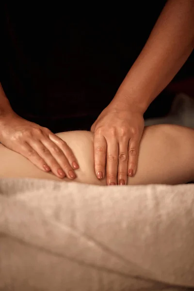 Close-up das mãos massagistas na perna do cliente. Imagem vertical. Sem rosto.. — Fotografia de Stock
