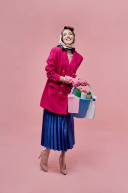 Tatmin olmuş bir kadın elinde bir kova temizlik aleti tutuyor..