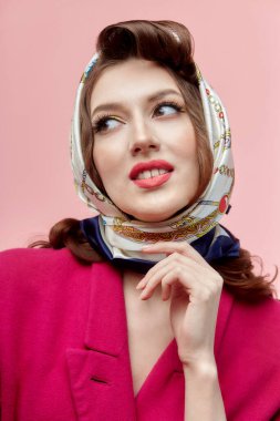 Parlak makyajlı genç esmer kadın. Başörtüsü. Dudaklarında kırmızı ruj var..