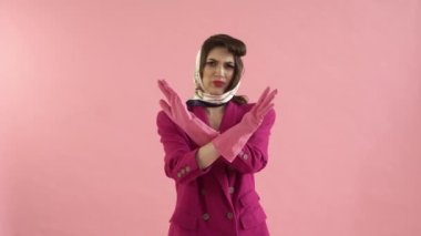 Kadın kollarını kavuşturur ve el hareketi yapmaz. Pembe lateks eldivenler..