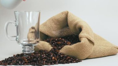 Temiz bir fincana taze kahve dök. Kahve çekirdekli bir çuval..
