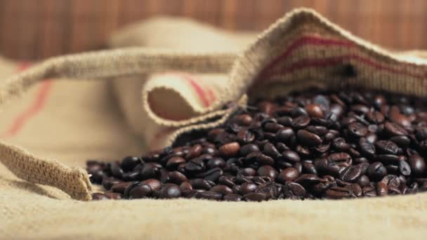 Close-up of dark beans of freshly roasted coffee in eco-friendly burlap bags — Stock Video
