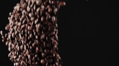 Siyah arka planda siyah kahve çekirdekleri uçar..