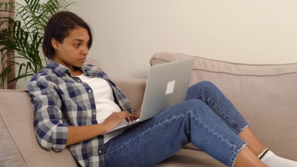 Όμορφη γυναίκα ελεύθερος επαγγελματίας που εργάζονται στο σπίτι σε απευθείας σύνδεση ξαπλωμένη με ένα φορητό υπολογιστή. — Αρχείο Βίντεο
