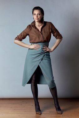 Kahverengi bluzlu güzel bir iş kadını ve uzun ve seksi bir etek..