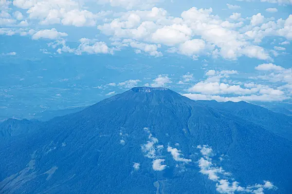 Dağların altında bulutlu mavi bir gökyüzü