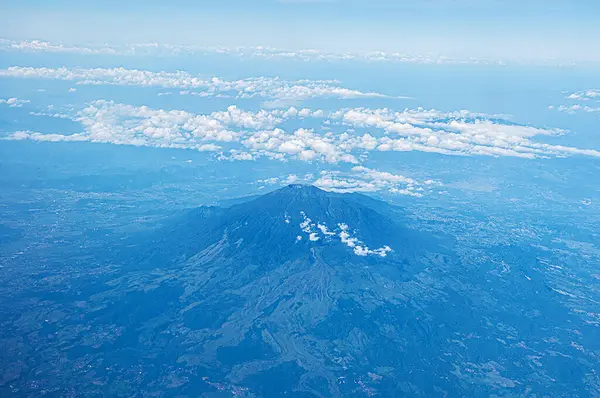 Dağların altında bulutlu mavi bir gökyüzü