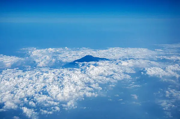 Dağların altında bulutlu mavi bir gökyüzü