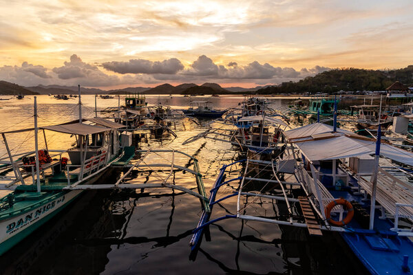 April 18, 2018: Typical Philippines Boats Moored on the harbour at sunset, Coron island 