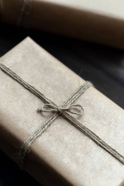 Noel hediyesi paketi ahşap masanın üzerinde el işi kağıda sarılmış bayram bayramını kutlamak için hazırlanmış.