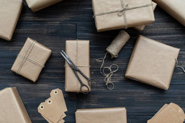 Świąteczne Pudełka Zapakowane Papier Rzemieślniczy Nad Drewnianym Stołem Przygotowane Świętowania — Zdjęcie stockowe