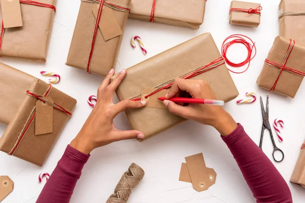 Female Hands Writing Christmas Cards Gift Boxes Decorated Kraft Paper — Stock Photo, Image