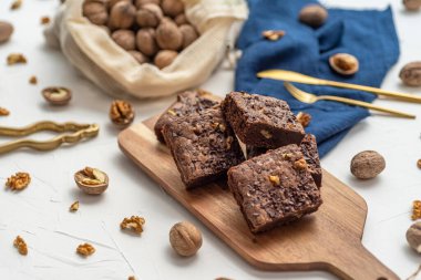 Beyaz zemin üzerinde istiflenmiş kek ve fındıkların üst görünümü