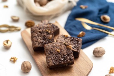 Beyaz zemin üzerinde istiflenmiş kek ve fındıkların üst görünümü