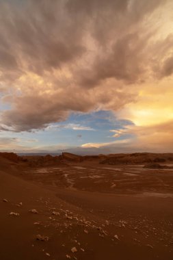Şili 'de güneşli bir günde kum tepeleri ve sert kayalıklarla Atacama Çölü manzarası