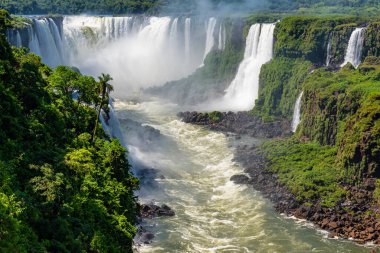 Arjantin ve Brezilya sınırındaki el değmemiş yeşil yağmur ormanlarından akan ünlü Iguazu Şelaleleri ve nehrin manzarası.
