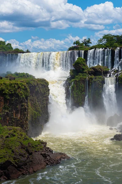 晴れた日には緑豊かな植生の間で水の流れが落ちるイグアスの滝の素晴らしい鮮やかな風景 — ストック写真