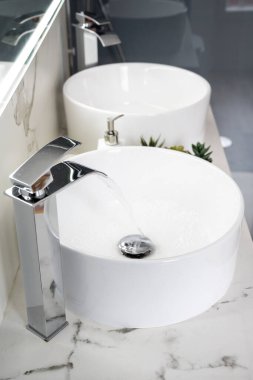 Bir çift seramik su havzası. Işıl ışıl, modern bir banyo.