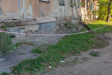 Çizgili uçuş yolu, evin duvarının sınırlı, dikkatli, acil durum durumudur, kırmızı ve beyaz şeritli bir apartman binasının çatlak alçı dokusudur. Havaalanının arka planındaki metro istasyonunda. Kırmızı beyaz uyarı bandı.