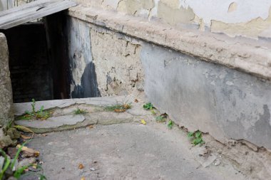 Evin eski bodrumuna giriş, beton çatlamış eski alçı sokak evinin duvarını boyuyor..