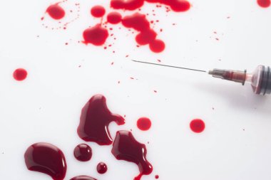 İnsan bağışıklık yetmezliği virüsü. Kanlı şırınga. Beyaz arka planda kan damlaları..