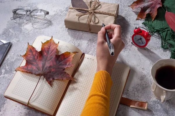 autumn flatlay top view. objects on gray-white texture. autumn leaves. holiday gift Autumn composition. Cup of coffee, blanket, autumn leaves on black background. Flat lay, top view, square