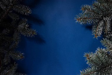 Noel ağacının detaylarıyla birlikte koyu mavi soğuk arka plan. Noel dokusu, düz çizgi. Mavi arka planda, üst manzarada, Noel 'in yukarıdan görüntüsü. El işi kağıdına sarılı, kırmızı Noel ağacı iple bağlanmış. koni oluştur 