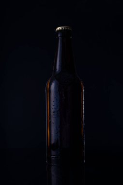 Siyah arka planda bira şişesi üzerinde bira şişesi. Reklam fotoğrafı