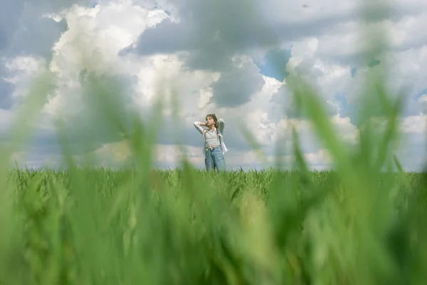 少女在青草中 在田野里 在乌云密布的天空中 — 图库照片