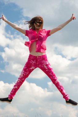 Bulutlu mavi gökyüzüne doğru pembe elbiseli şık bir kız atlıyor..