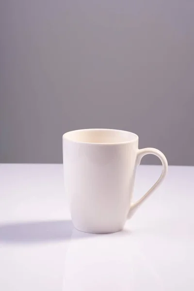 empty white cup on white gray background minimalistic concept.