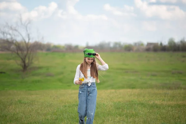 穿着风衣在绿草上散步的时髦少女 — 图库照片